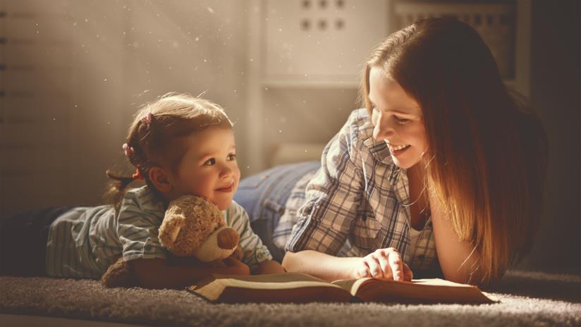 Il momento della lettura condivisa è speciale sia per i genitori sia per i bambini Una mamma legge un libro con la sua bambina