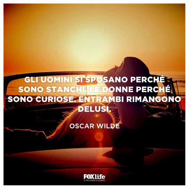 Aforisma Oscar Wilde Giovane coppia in auto guarda il tramonto