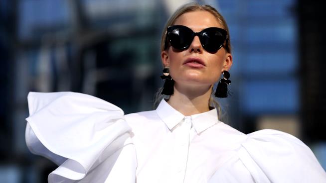 La modella indossa una camicia bianca con le maniche a sbuffo Un look da street style con camicia bon ton
