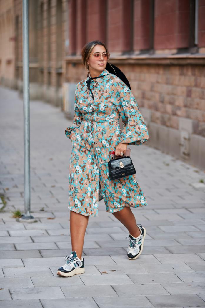 Sneakers abbinate a un abito midi floreale Sneakers indossate con un abito a stampa floreale