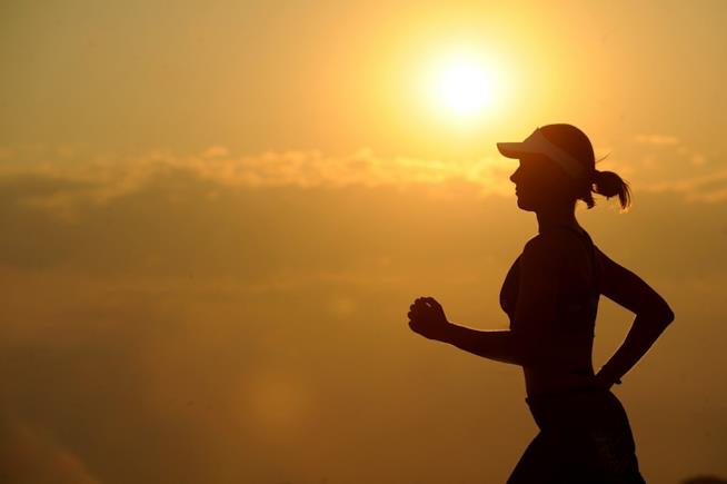 Cosa succede al nostro corpo quando smettiamo di allenarci? Ecco la risposta. Una donna che corre al tramonto.