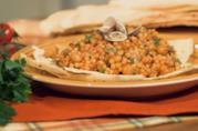 Fregola con vongole e ceci: la ricetta di Giallo Zafferano Primo piano di fregola sarda con vongole e ceci su piatto bianco