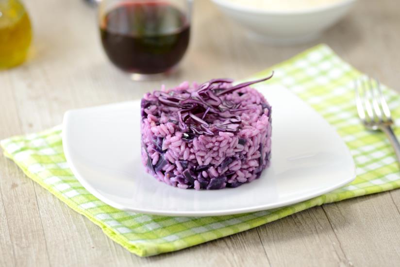 Risotto con cavolo rosso: la ricetta Piatto bianco con risotto con cavolo rosso, su tovaglia a quadri bianchi e gialli
