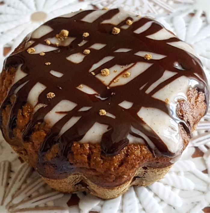 Cupcke di zucca con topping Dolcetto guarnito con strisce di crema bianca e cioccolato