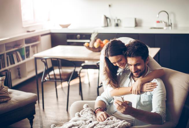 7 tappe di una relazione che 10 anni fa non esistevano Una giovane coppia consulta lo smartphone