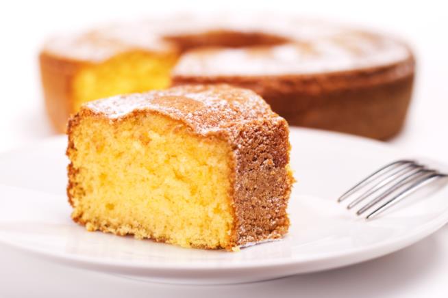 Ciambella allo yogurt per una colazione sana e leggera: un dolce sano e gustoso senza burro da tuffare nel caffelatte o da gustare per merenda Ciambella allo yogurt tagliata a fette su piatto in ceramica bianco e forchetta