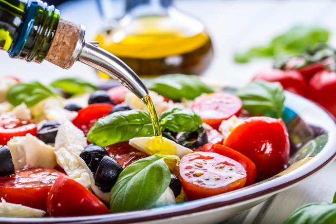 I cibi che aiutano a rimanere in forma Piatto d'insalata caprese condito con dell'olio EVO