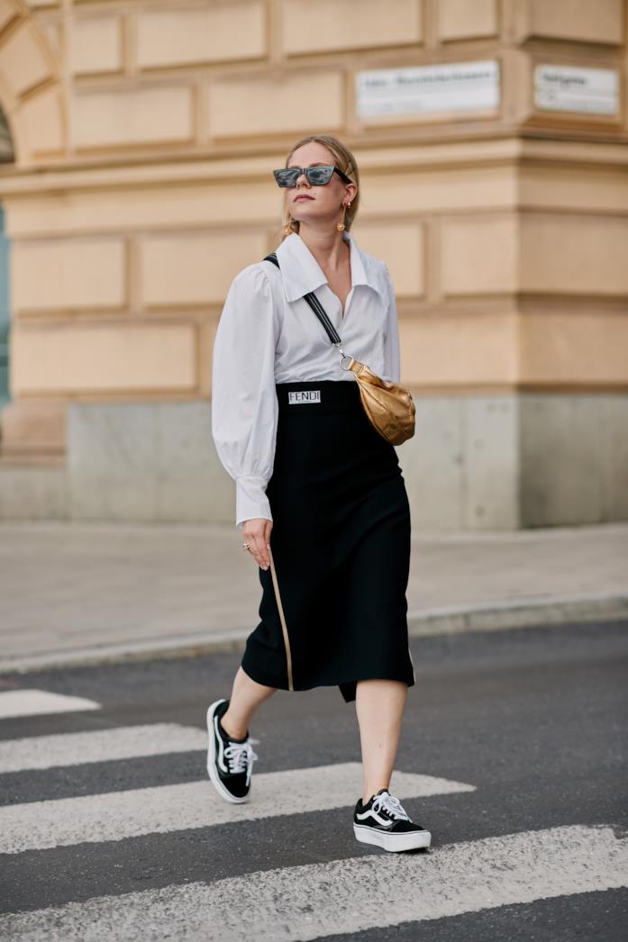 Sneakers indossate con pencil skirt e camicia Sneakers abbinate a gonna a matita e camicia