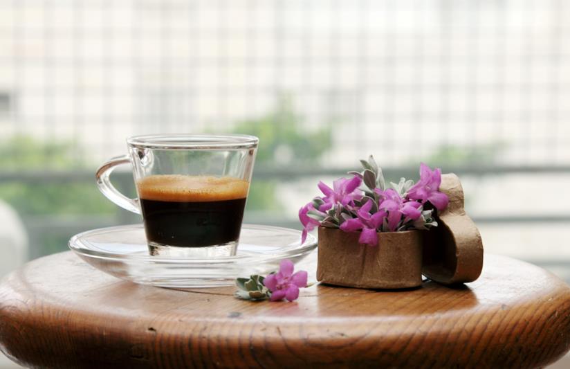 Il caffè fa bene alla salute se bevuto con regolarità Bicchiere con caffè espresso su un tavolino