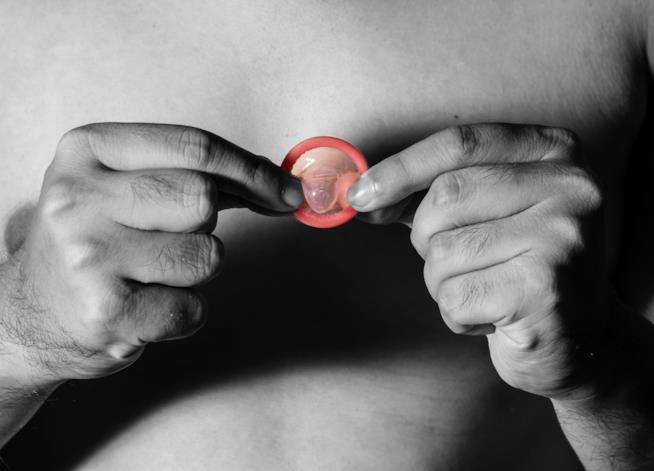 Lo stealthing, la nuova frontiera dell'abuso sessuale Uomo con preservativo, concetto di salute.