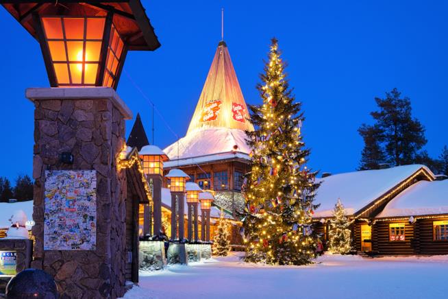 Quale albero di Natale scegliere per le festività Un albero natalizio addobbato fuori una casa