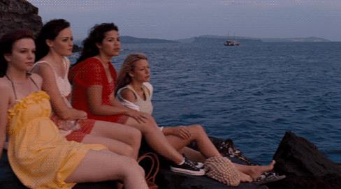 4 amiche e un paio di jeans le quattro amiche sedute in riva al mare