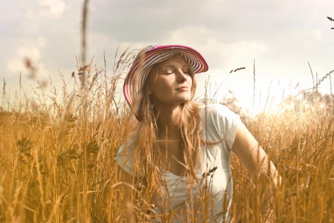 Carenza da Vitamina D Ragazza seduta in un campo prende il sole