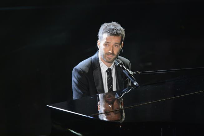 Daniele Silvestri a Sanremo Daniele Silvestri, seduto al pianoforte, in nero, su sfondo nero