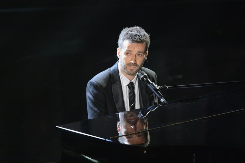 Daniele Silvestri a Sanremo Daniele Silvestri, seduto al pianoforte, in nero, su sfondo nero