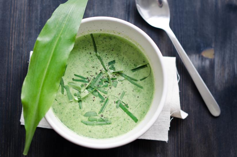 Come preparare una deliziosa vellutata all'aglio orsino: un primo piatto veloce da realizzare e dal gusto inconfondibile Vellutata verde di aglio orsino in piatto circolare con foglia decorativa
