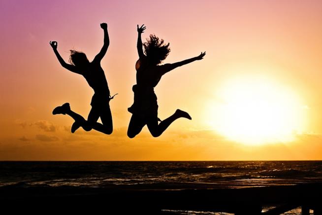 Dall'esercizio quotidiano alla dieta: i segreti per rallentare l’invecchiamento. Due ragazze che saltano al tramonto.