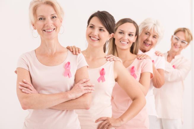 Studio rivela legame tra arrivo del ciclo e salute delle donne Un gruppo di donne con il fiocco rosa della ricerca
