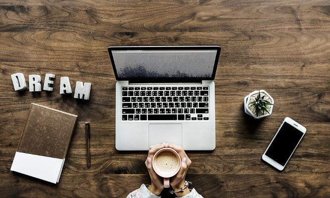 Visto lavorativo per gli USA Scrivania con laptop, smartphone e altri oggetti di lavoro