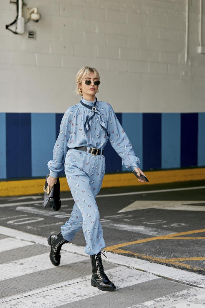 Jumpsuit stampata indossata con stivaletti stringati e borsa a mano nera Jumpsuit stampata abbinata a stivaletti stringati e borsa a mano nera