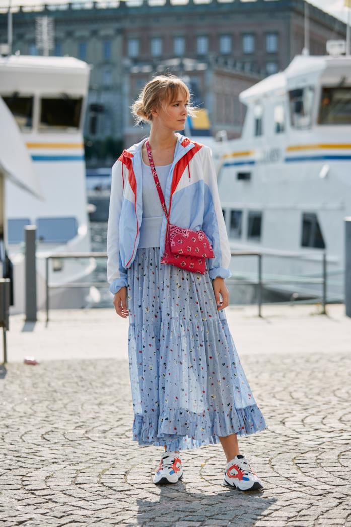 Sneakers colorate abbinate a maxi gonna e giacca casual Sneakers indossate con gonna lunga stampata e giacca bomber