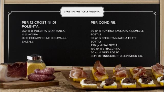 La ricetta dei crostini rustici di polenta con stracchino e salsiccia Primo piano di crostini di polenta con salsiccia e stracchino su tavolo da cucina