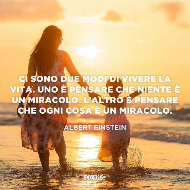 Citazione Einstein Madre e bambino passeggiano in riva al mare tenendosi per mano