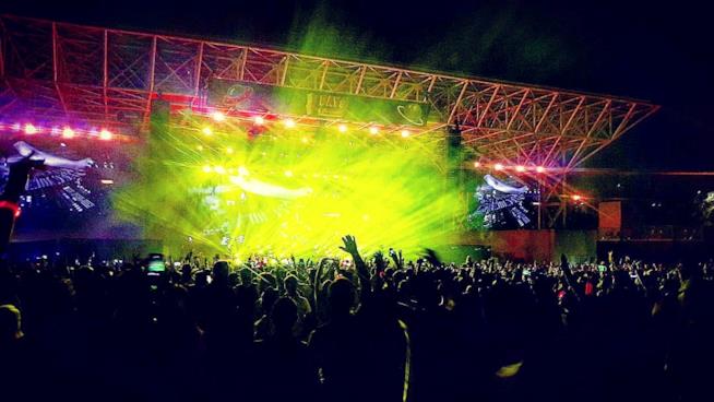 I festival dell'estate Pubblico a un festival con le braccia alzate e luce gialla dal palco