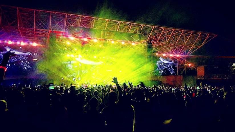 I festival dell'estate Pubblico a un festival con le braccia alzate e luce gialla dal palco