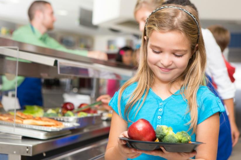Esplode lo scandalo delle mense scolastiche: cosa mangiano i nostri figli? Bambina in mensa scolastica con vassoio