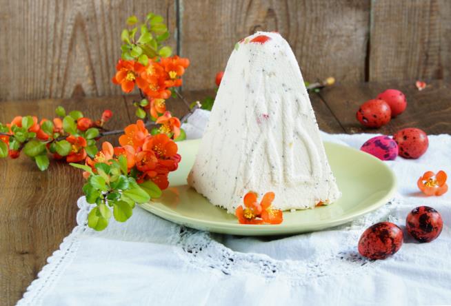 Ricetta della cassata Primo piano della cassata realizzata a forma di piramide su tavolo da cucina di colore scuro