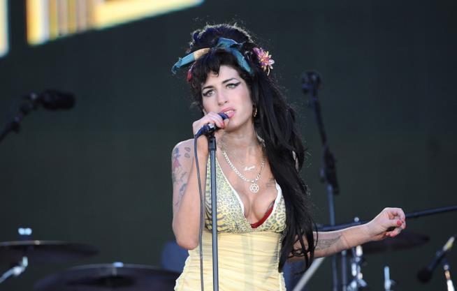 Spunta un inedito che Amy Winehouse registrò a 17 anni Amy Winehouse canta al microfono, indossando un abito giallo