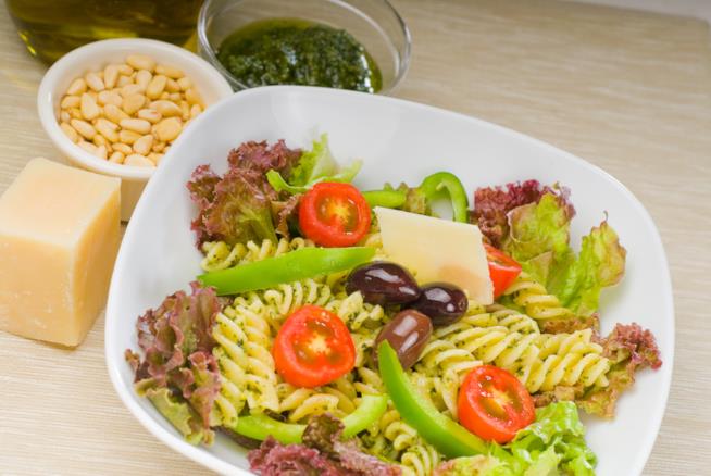 Ricetta dei fusilli freddi al pesto, pinoli, parmigiano, olive e verdure estive Fusilli freddi al pesto, pinoli, parmigiano, olive e verdure