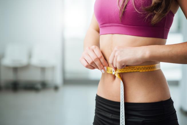 La GM Diet è la dieta dell'estate 2017 Una ragazza si misura la vita con il centimetro