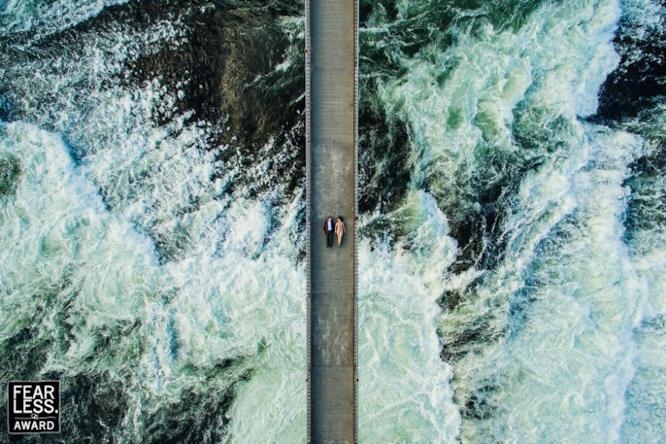insieme nella tempesta una coppia su un ponte sospeso sul mare in tempesta