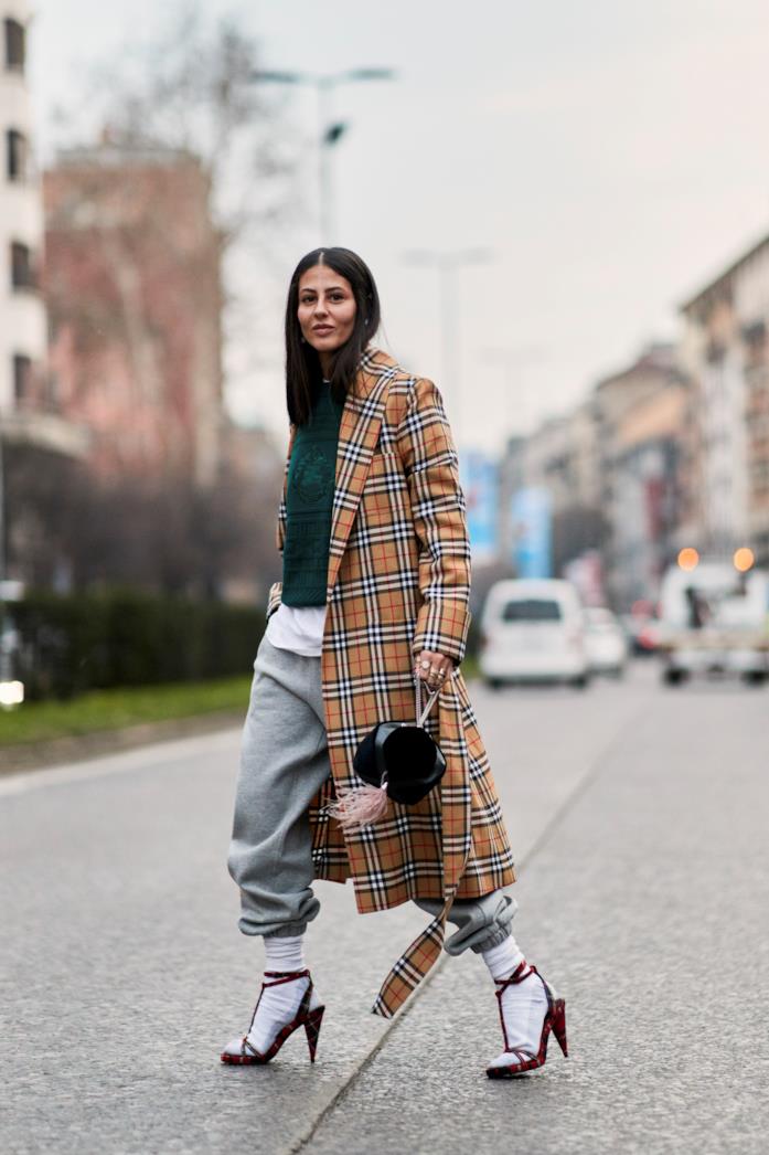 Trench di Burberry, pantaloni della tuta e sandali con calzino a vista per l'influencer L'influencer indossa trench di Burberry, pantaloni della tuta e sandali con calzino a vista