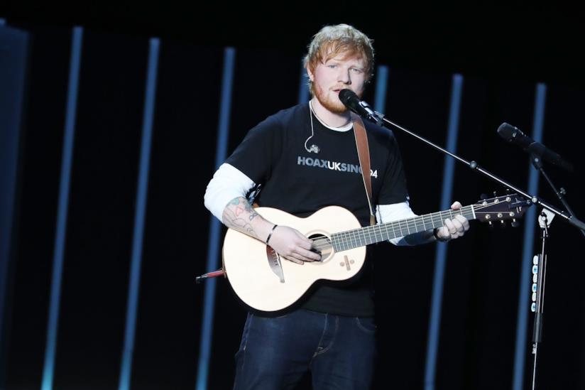 Il concerto di Ed Sheeran a San Siro Ed Sheeran in piedi, con la chitarra in mano, canta al microfono