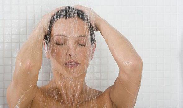 Lavarli troppo spesso, rende i capelli lisci deboli. Donna che si fa la doccia.