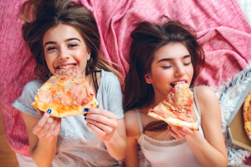 pizza a colazione due ragazze mangiano pizza a letto