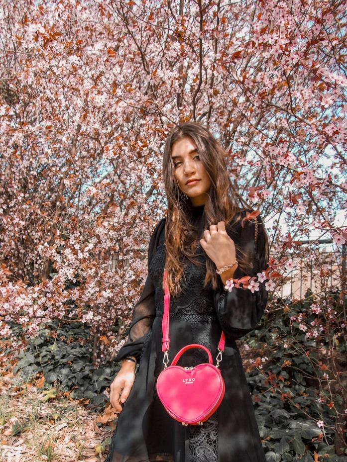 Arianna Cavina Arianna Cavina con maxi dress nero e borsa fucsia a cuore