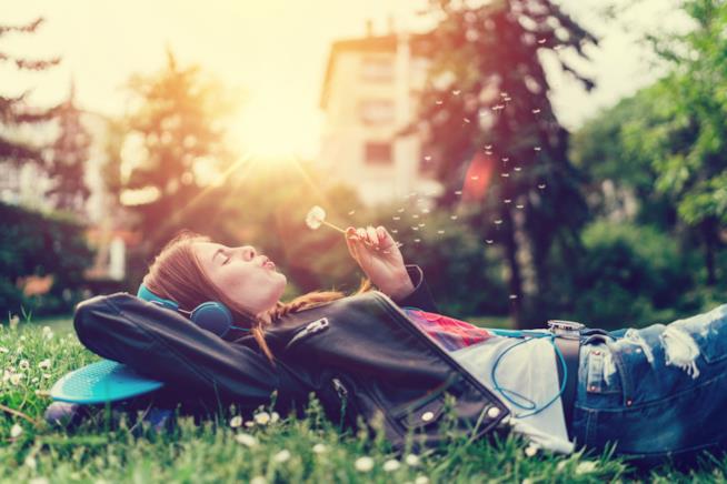 Ragazza ascolta un libro al parco Audiolibri: il nuovo modo per leggere dove vuoi