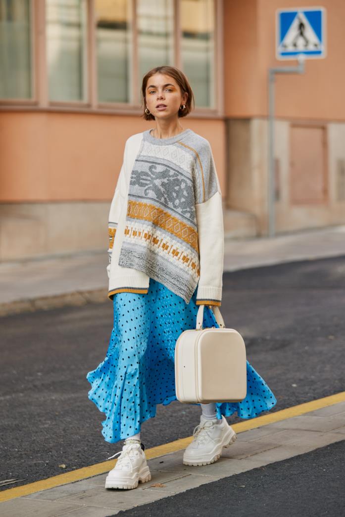 Gonna in raso azzurra abbinata a pullover coordinato e sneakers Una maxi gonna in raso indossata con maglione e sneakers