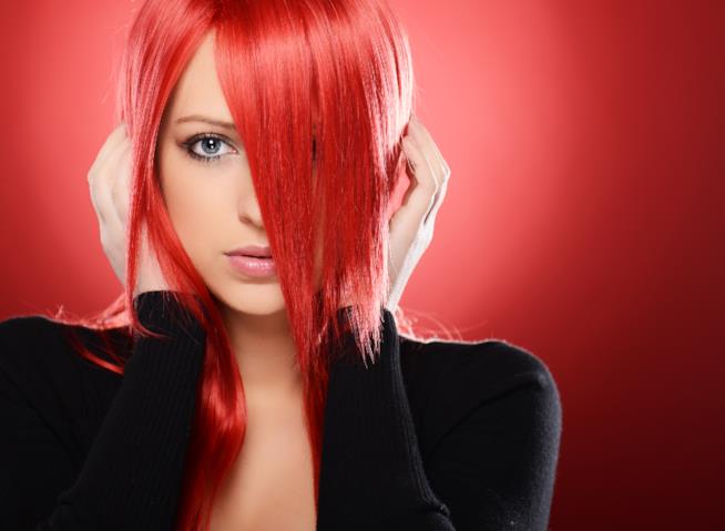 Gli errori più comuni che danneggiano i capelli delle ragazze Bella ragazza rossa che tiene le mani sui capelli, altezza orecchie