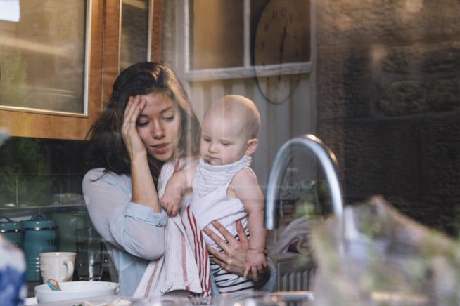 Mamma disperata con piatti, bambini, faccende da fare... A casa con tutto da fare, la mamma sull'orlo della disperazione