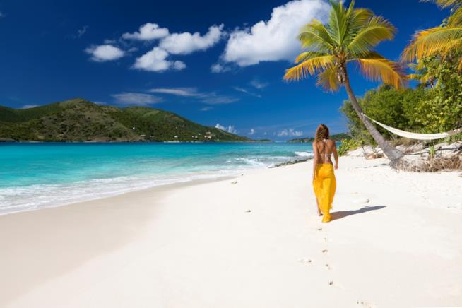 Donna che cammina su una spiaggia dei Caraibi Una spiaggia da sogno dei Caraibi