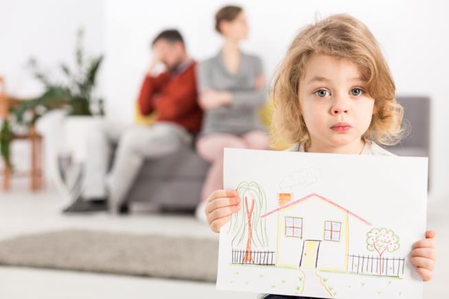 Il divorzio può causare la separazione dai figli Una bambina tiene in mano il disegno di una casa