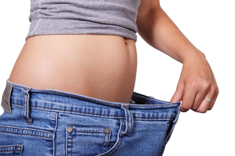 Dimagrire con le diete estive Ragazza che controlla l'ampiezza dei jeans