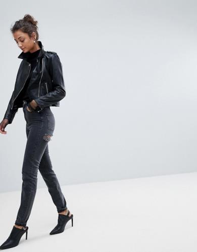 Jeans skinny neri con strappi sotto il gluteo