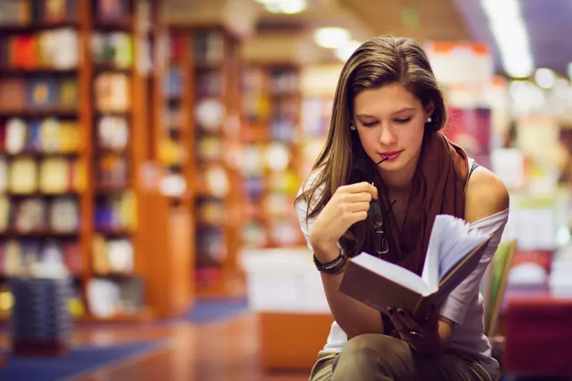 Frasi Cesare Pavese Ragazza legge un libro in biblioteca