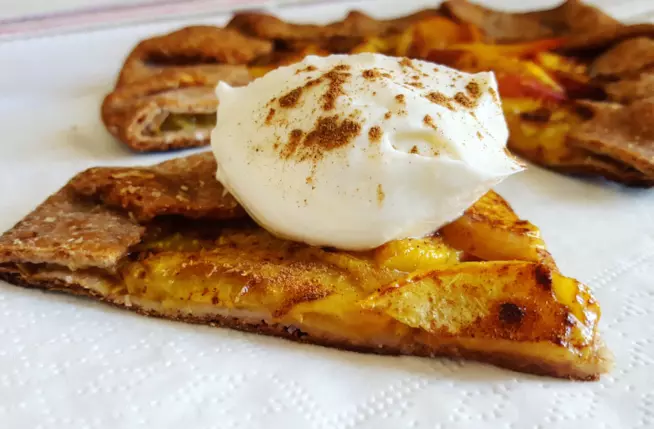 Galletta di pesche Fetta di crostata con frutta e crema sopra